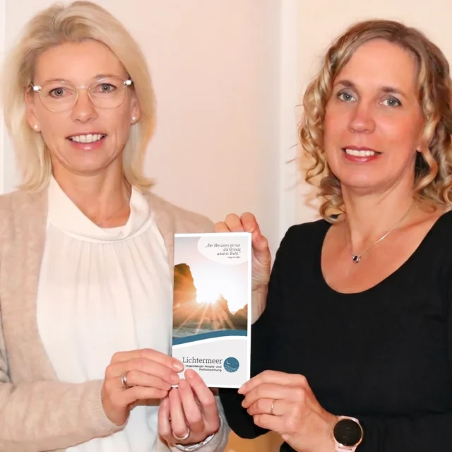 Tanja Bohn und Barbara Becker präsentieren lächelnd den neuen Informationsflyer der Lichtermeer Stiftung.